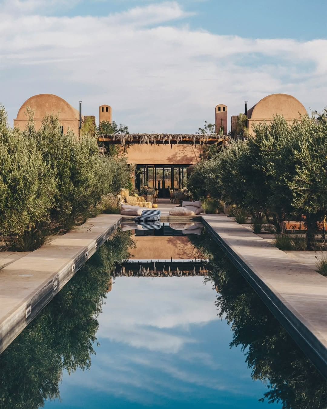 The 50-metre lap pool reflects the twin domes of the farmhouse at the end of the day
