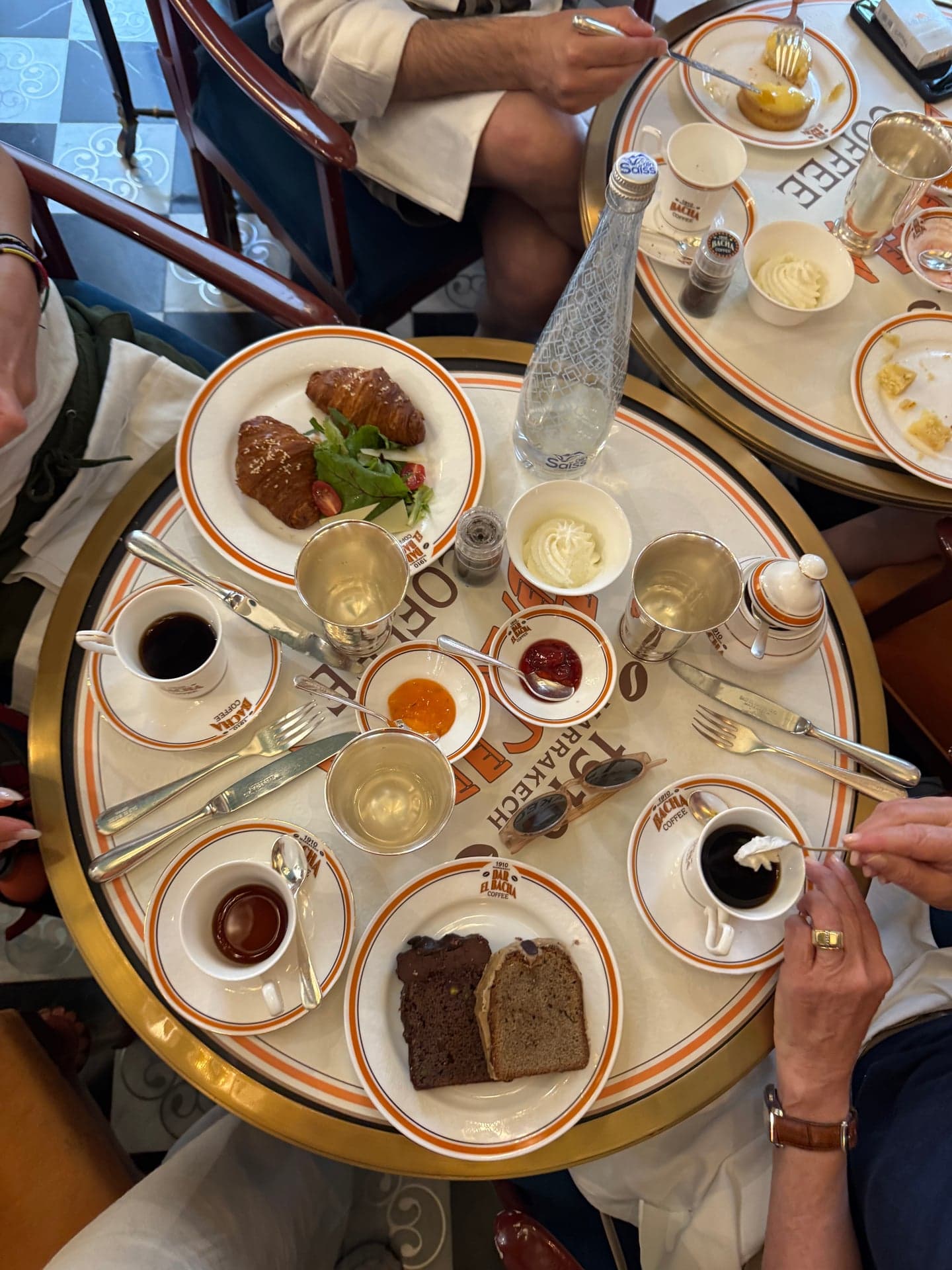A petit dejeuner spread: coffee, eggs, croissants, cakes and bottled water