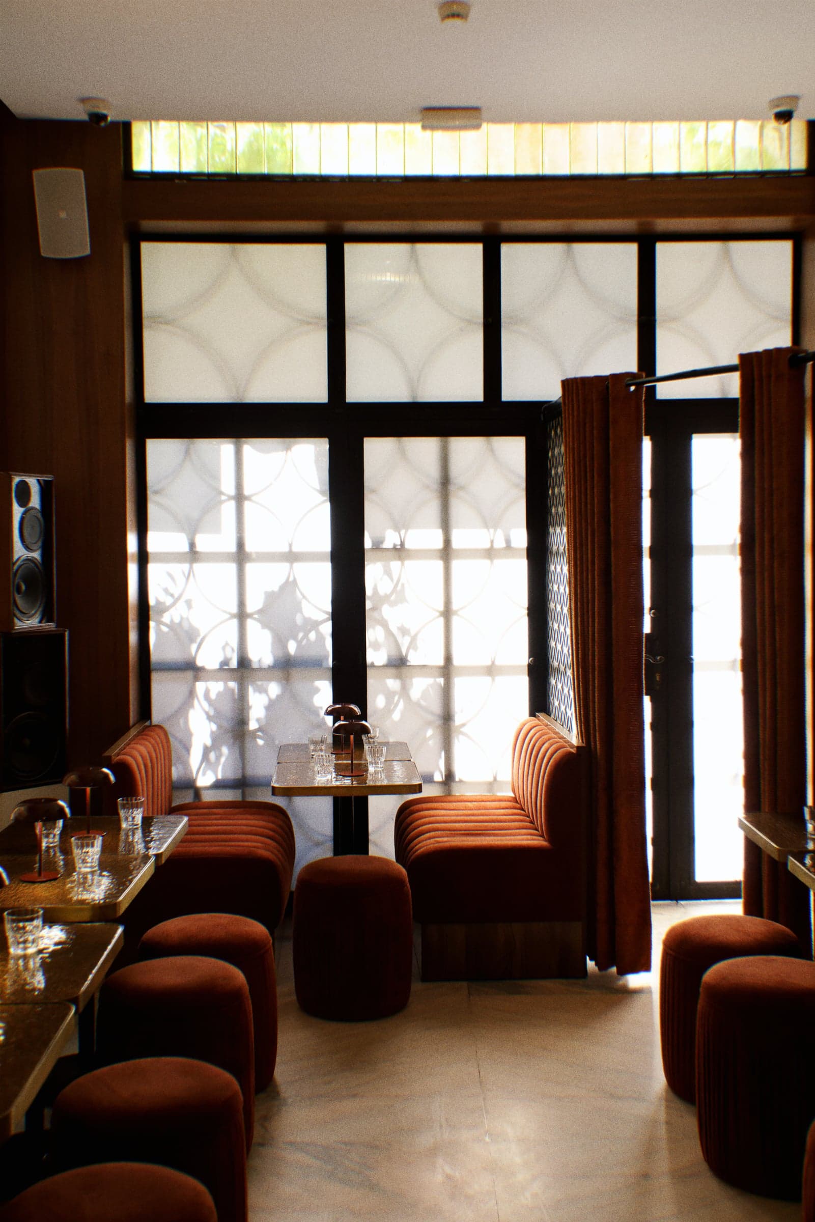 Channel-tufted banquettes face the yellow brick windows